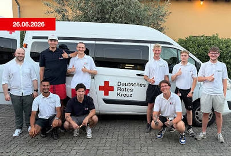 Team des DRK-Ortsvereins Ludwigshafen-Nord vor einem Rotkreuz-Fahrzeug, mehrere Personen strecken den Daumen nach oben